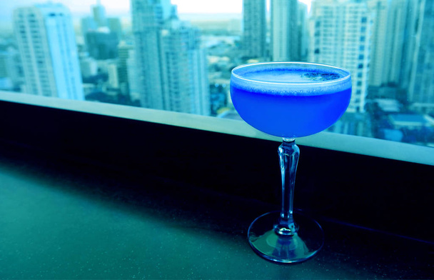 Pop art stílus királyi kék színű koktél világoskék felhőkarcolók légi kilátás a háttérben - Fotó, kép