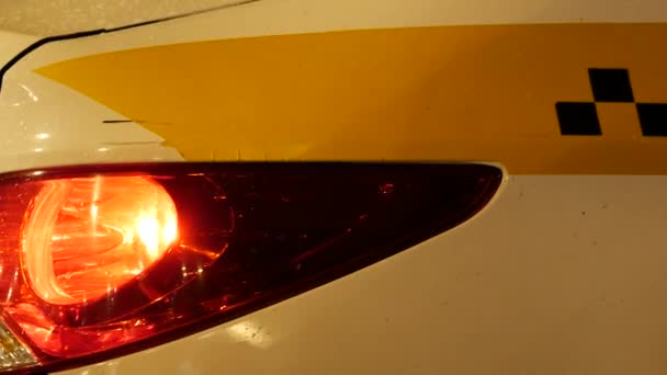 夜の車の後ろ。街路灯だ黒いチェッカー付きのタクシーのエンブレム - 映像、動画