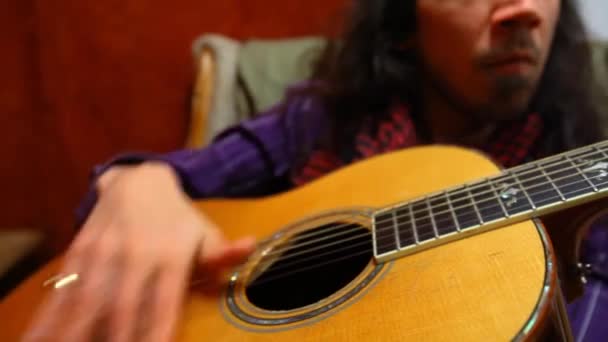 Člověk hrát na kytaru v obývacím pokoji. - Záběry, video