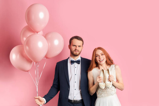 Sctrict fiance and happy bride isolated over pink background - Fotoğraf, Görsel