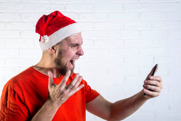 Santa screaming at mobile phone on a white background. - Фото, изображение