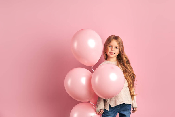 Charming girl kid with pink air balloons isolated over pink background - Φωτογραφία, εικόνα