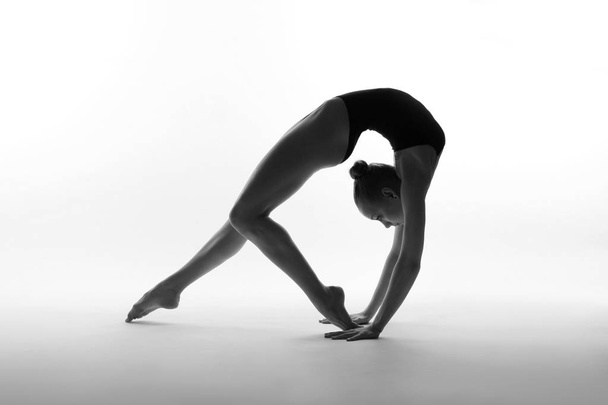 Flexible girl posing in black leotard - Foto, Imagen