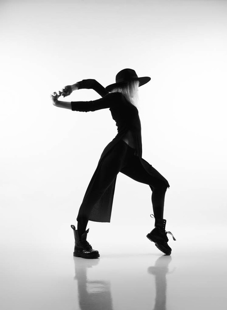 Sportif kız siyah mayo ve beyaz spor ayakkabılarla egzersiz tahtası yapıyor. Siyah beyaz fotoğraf. - Fotoğraf, Görsel