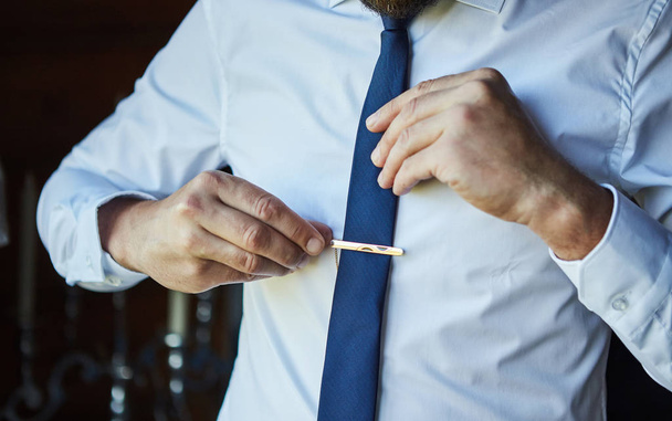 mies paidassa pukeutumassa ja säätämässä solmiota kaulassa kotona. Miesten muoti - Valokuva, kuva