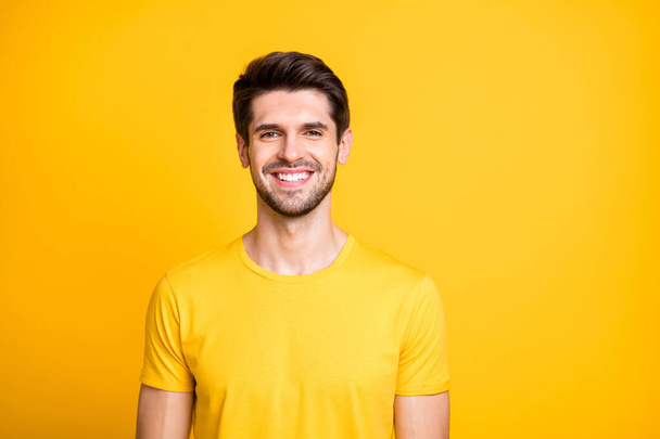 Close-up portrait of his he nice attractive cheerful cheery guy wearing tshirt smiling isolated over bright vivid shine vibrant yellow color background - 写真・画像