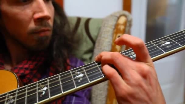Mężczyzna gra na gitarze w pokoju dziennym. - Materiał filmowy, wideo