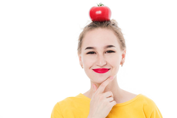 Krásná dívka drží rajče v rukou, na bílém izolovaném pozadí. Koncept zdravé stravy a stravy. - Fotografie, Obrázek