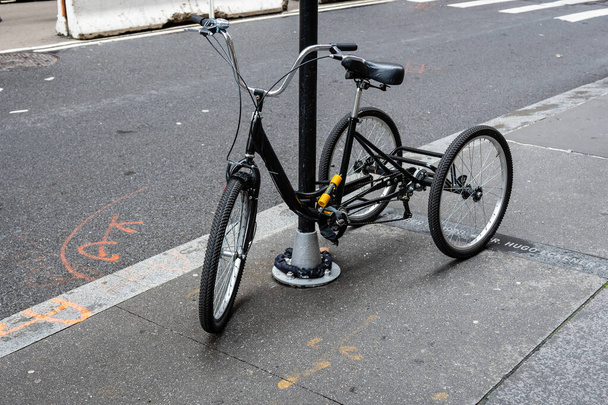New York, USA - June 21, 2019:  A black tricycle parked on the side of a street in Manhattan - image - Foto, Imagem
