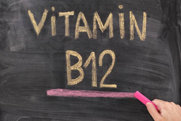 Man writing words Vitamin B12 on chalkboard - Valokuva, kuva