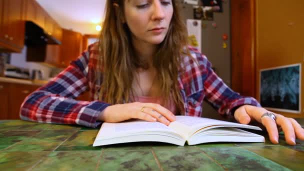 Mulher está lendo um livro na mesa
 - Filmagem, Vídeo