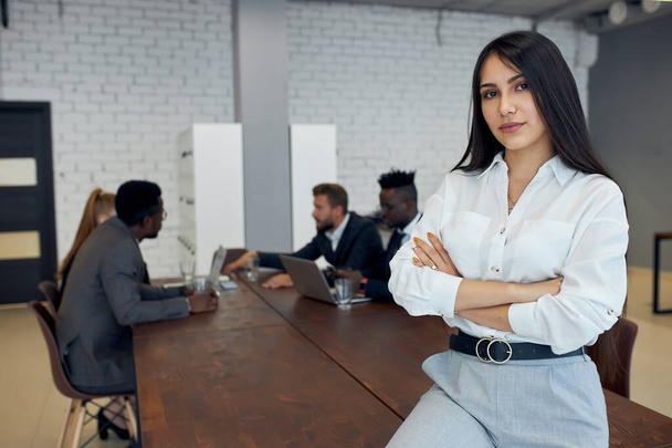 Portrait of caucasian young business woman sitting in an office environment - Photo, Image