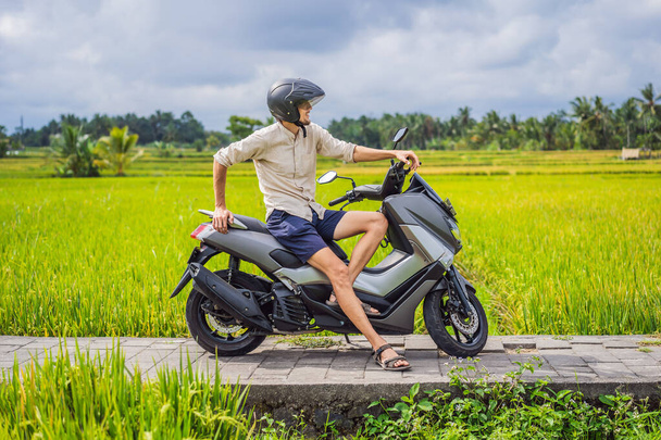 Male traveler on a bike among a rice field. Tourist travels to Bali - Foto, imagen