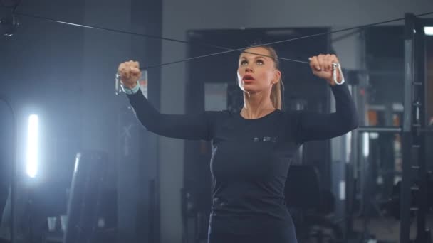 The girl shakes the muscles of the chest and arms in the gym - Footage, Video