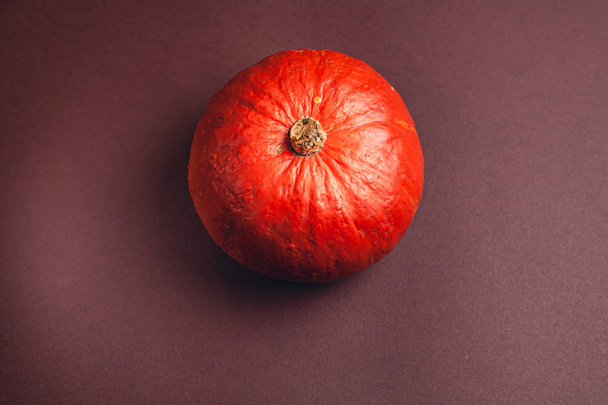 Stock photo of a pumpkin on a brown background with place for text. Varietal seasonal pumpkins. - Fotó, kép