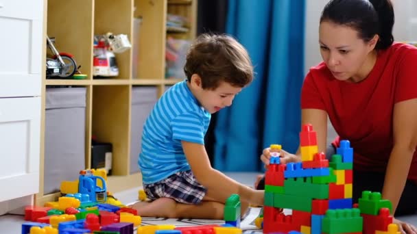 moeder spelen kleurrijke plastic blokken speelgoed met haar zoon, concept voor moeder en zoon samen spelen. - Video