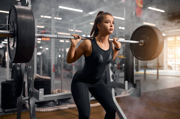 Pretty fit woman squatting with weight - Foto, immagini