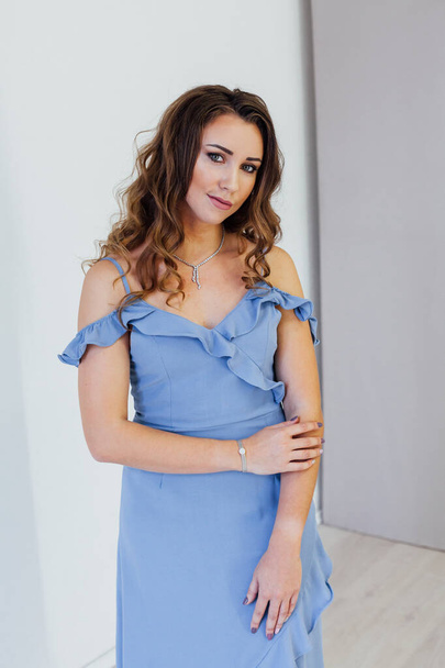 Portrait of a beautiful fashionable woman with curls in a blue dress - Photo, Image