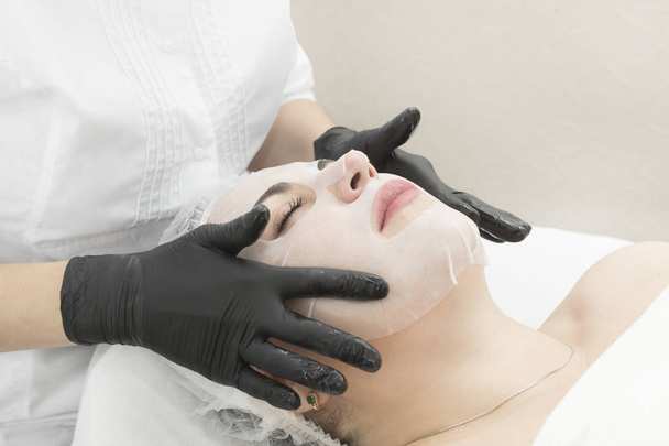 Menettely on puhdistava korjaava märkä naamio naiselle kauneushoitolassa
. - Valokuva, kuva