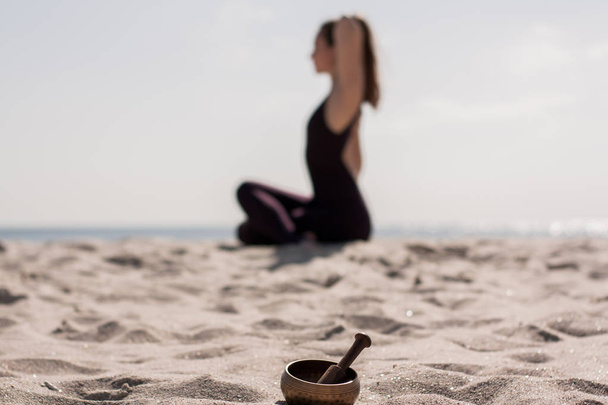 Joga kobieta ćwiczy na macie na plaży na porannym słońcu świecą  - Zdjęcie, obraz