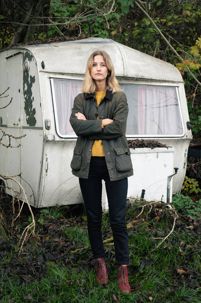 Blonde woman standing in front of old camper - Photo, Image