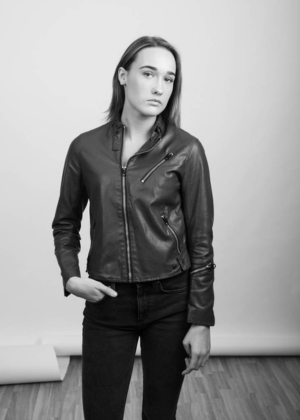 革のジャケットを着た若い女性のグレースケールの肖像画 - 写真・画像