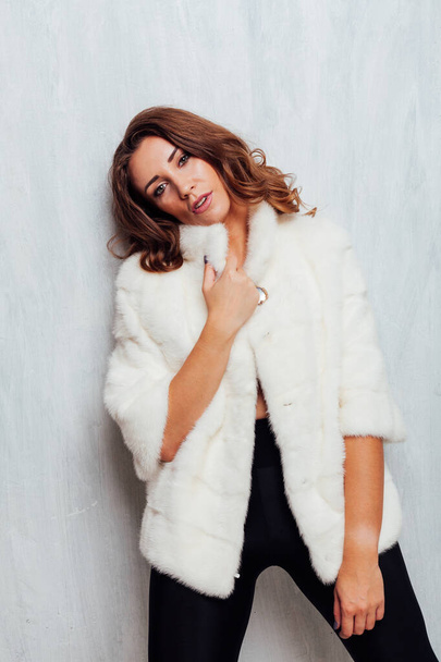 portrait of a beautiful fashionable woman with curls in a white fur coat - Foto, Bild
