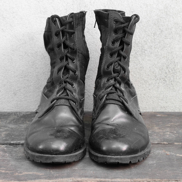 Παλιές μαύρες μπότες στο ξύλινο. - Φωτογραφία, εικόνα