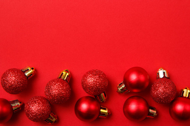 Karácsonyi üdvözlőlap kompozíció. Karácsonyi piros golyó dekoráció piros háttér. Lapos fekvés, felülnézet, másolás - Fotó, kép