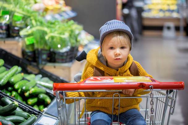 Fashion toddler boy with backpack, shopping in supermarket - Фото, зображення