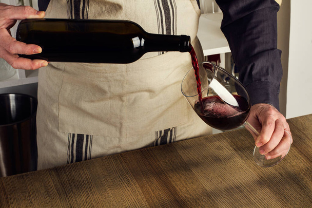 Człowiek podający kieliszek czerwonego wina - Zdjęcie, obraz