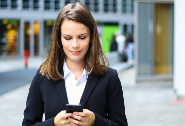 Smiling businesswoman using a smartphone - Photo, image