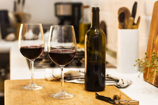 Ένα μπουκάλι κρασί και ένα ποτήρι σε έναν πάγκο. - Φωτογραφία, εικόνα