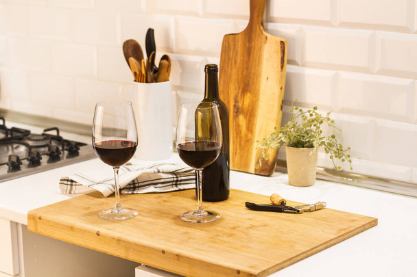 Uma garrafa de vinho e vidro em um balcão
 - Foto, Imagem