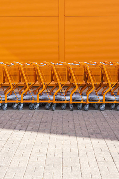Orange shopping cart stacked by the entrance - Φωτογραφία, εικόνα
