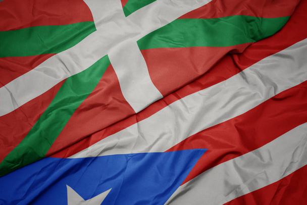 ondeando colorida bandera de puerto rico y bandera nacional del país vasco
. - Foto, Imagen