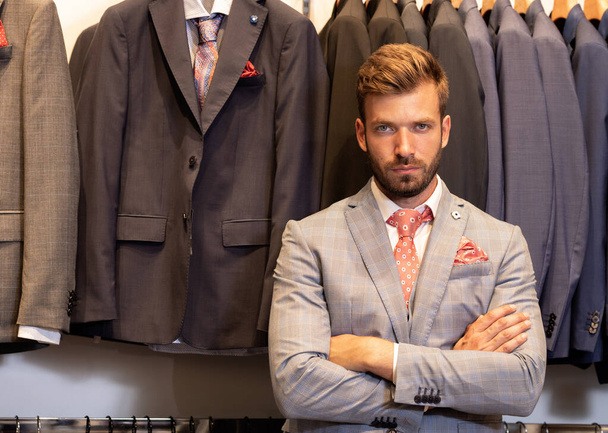 Man in suit posing in boutique of man’s suits  - Photo, Image