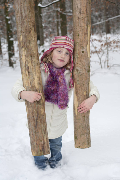 A strong girl holding a tree trunk. - Photo, Image