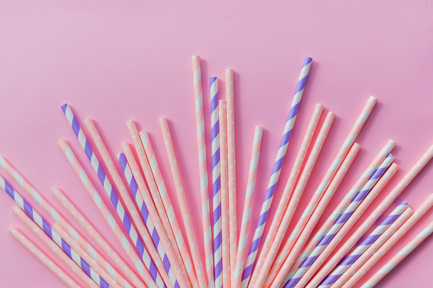 Striped drink straws of different colors in row isolated on yellow background. Minimalism concept. Pop art style. Flat lay with straws. Birthday Party Celebration Kids Fun. Greeting Card Poster - Foto, afbeelding