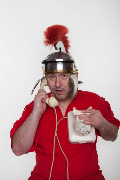 Um soldado romano está ao telefone.
  - Foto, Imagem