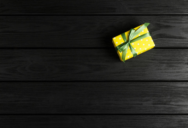 Ansicht einer Geschenkbox auf schwarzem Holzhintergrund - Foto, Bild