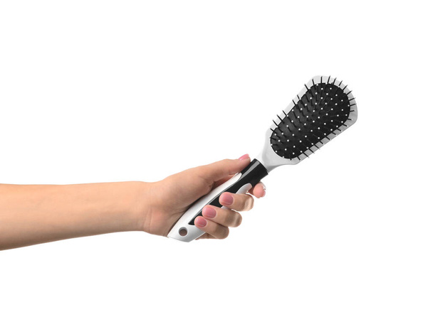 Female hand with hairbrush on white background - 写真・画像