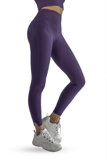 Красиві тонкі жіночі ноги в фіолетових спортивних легінсах і взутті для бігу ізольовані на білому тлі. Концепція стильного одягу, спорту, краси, моди та тонких ніг
 - Фото, зображення