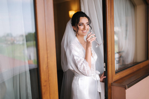 Retrato de noiva linda no hotel de manhã. Mulher encantadora com grande penteado e maquiagem
 - Foto, Imagem