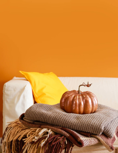 Pumpkin with plaids on table in room - Photo, Image