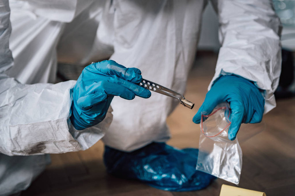 Expert médico-légal recueillant des douilles de balles d'une scène de crime
 - Photo, image
