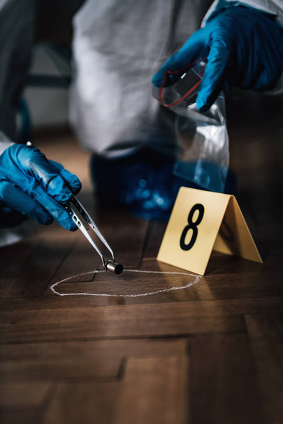 Esperto forense che raccoglie bossoli da una scena del crimine
 - Foto, immagini