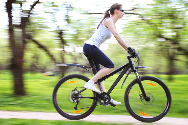 Bella donna con bicicletta in un parco verde
 - Foto, immagini