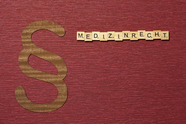 Bordo renk arkaplanındaki işaret paragrafı. Almanca kelime Medizinrecht - Fotoğraf, Görsel