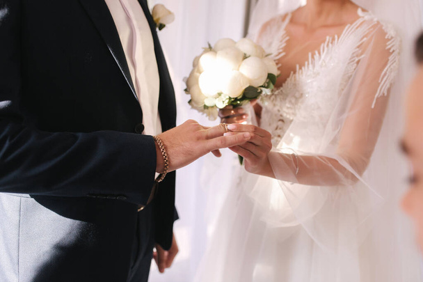 Selección intermedia de recién casados poniendo los anillos entre sí
 - Foto, Imagen